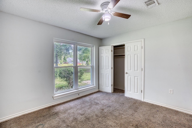 246 Pinevale Way, Sour Lake, TX 77659 - unfurnished bedroom featuring a textured ceiling, carpet floors, a closet, ceiling fan, and baseboards