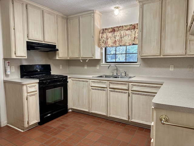 kitchen with black gas stove, cream cabinetry, a textured ceiling, and sink