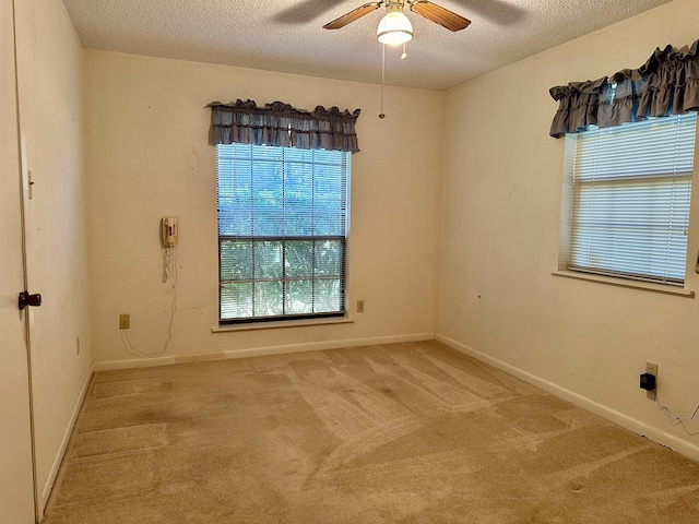 carpeted empty room with ceiling fan and a textured ceiling