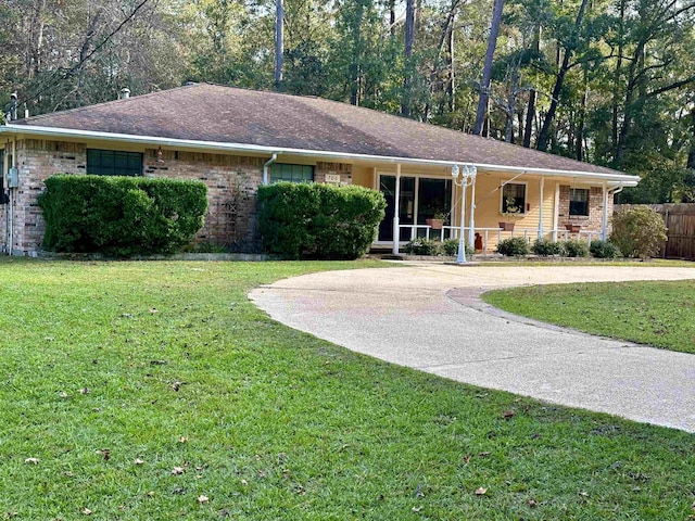 single story home featuring covered porch and a front yard