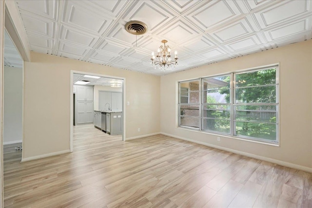 2701 Mcbride Dr, Port Neches, TX 77651 - spare room with a chandelier, light wood finished floors, and an ornate ceiling