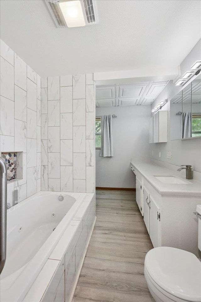 2701 Mcbride Dr, Port Neches, TX 77651 - full bathroom featuring a tub with jets, vanity, and wood finished floors