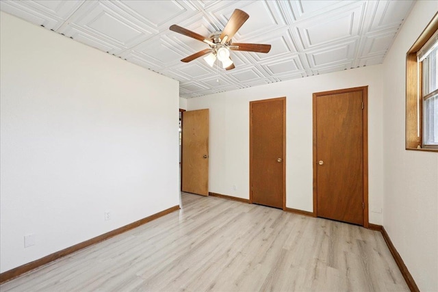 2701 Mcbride Dr, Port Neches, TX 77651 - unfurnished bedroom featuring light wood-style flooring, an ornate ceiling, multiple closets, and ceiling fan