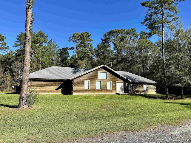 view of front facade featuring a front lawn, log exterior, and metal roof