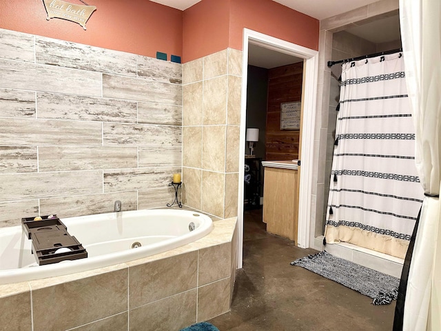 full bath featuring tile walls, a garden tub, finished concrete floors, and curtained shower