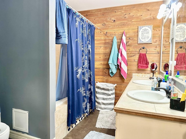 bathroom with a sink, double vanity, wooden walls, and curtained shower
