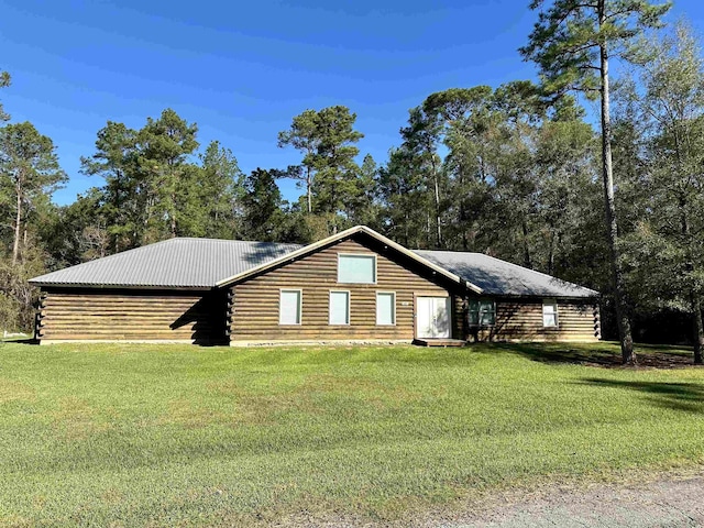 exterior space featuring metal roof, log siding, and a front yard