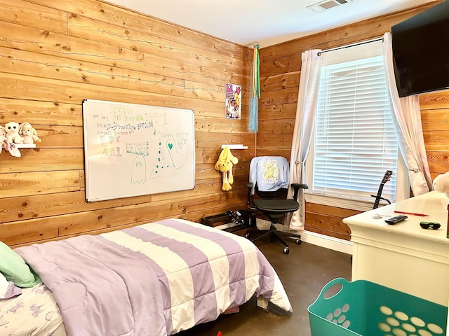 bedroom featuring finished concrete floors, wood walls, baseboards, and visible vents