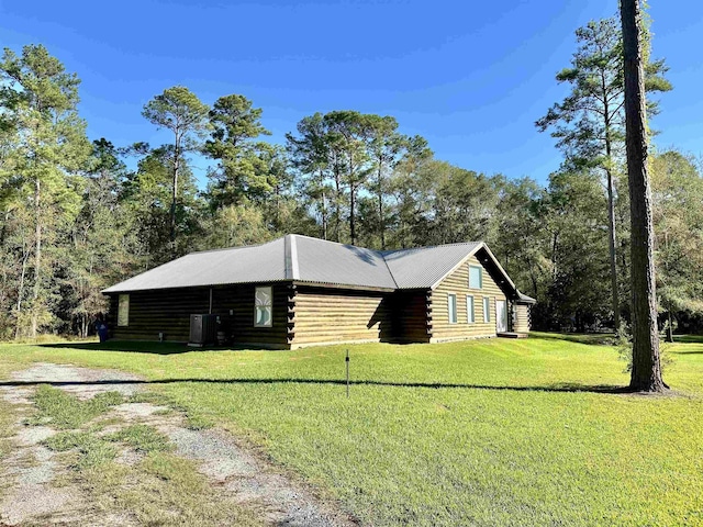 view of side of home featuring a yard, log siding, and central AC