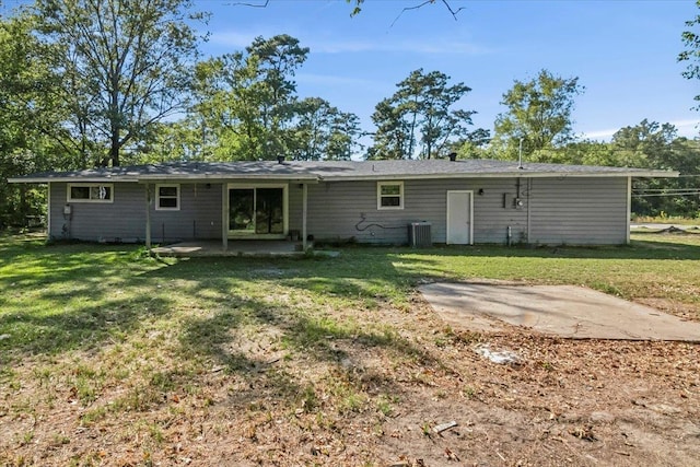 back of property featuring a lawn, a patio, and central AC