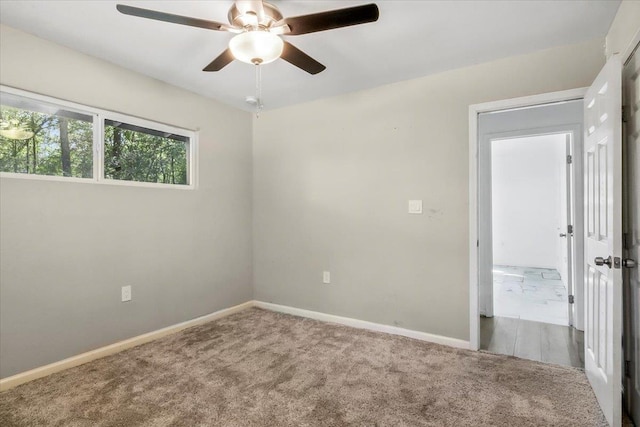 carpeted spare room featuring ceiling fan