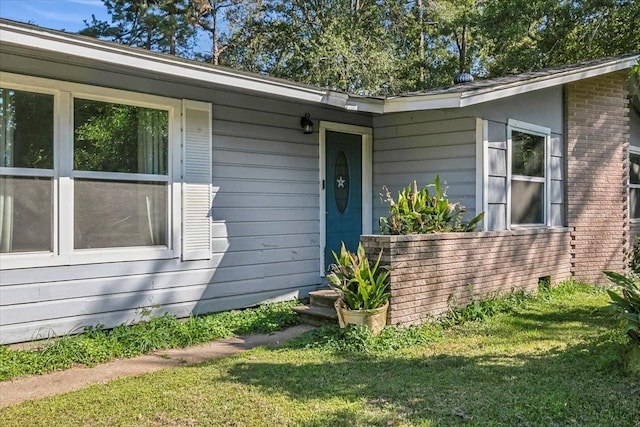 view of exterior entry featuring a yard