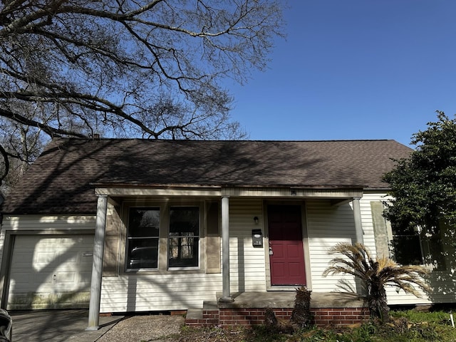 view of front of home with a shingled roof and a garage