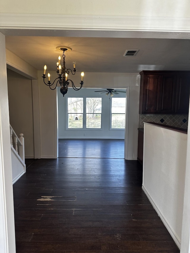 unfurnished dining area with stairway, baseboards, visible vents, and dark wood-type flooring