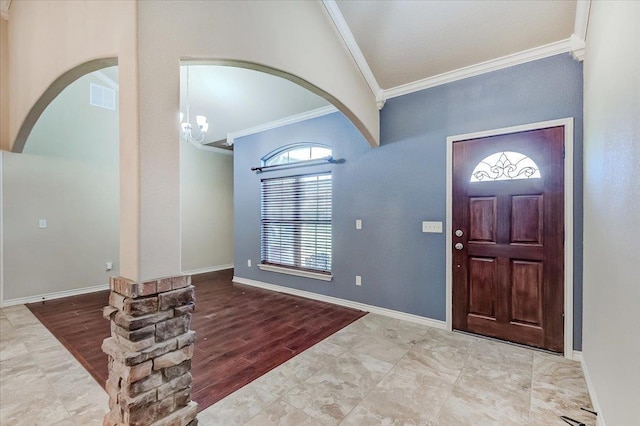 entrance foyer featuring vaulted ceiling, light hardwood / wood-style flooring, ornamental molding, and a notable chandelier