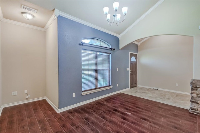 entryway with crown molding, vaulted ceiling, and a notable chandelier