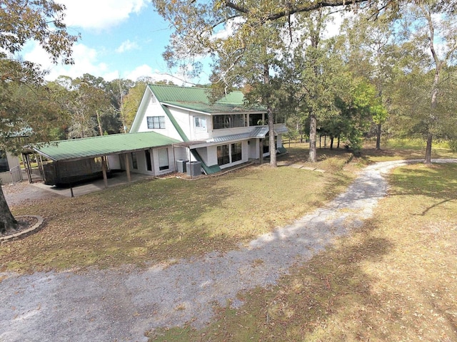 view of front of home with a front yard, central AC unit, and a carport