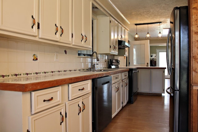 kitchen with tasteful backsplash, stainless steel appliances, sink, pendant lighting, and dark hardwood / wood-style floors