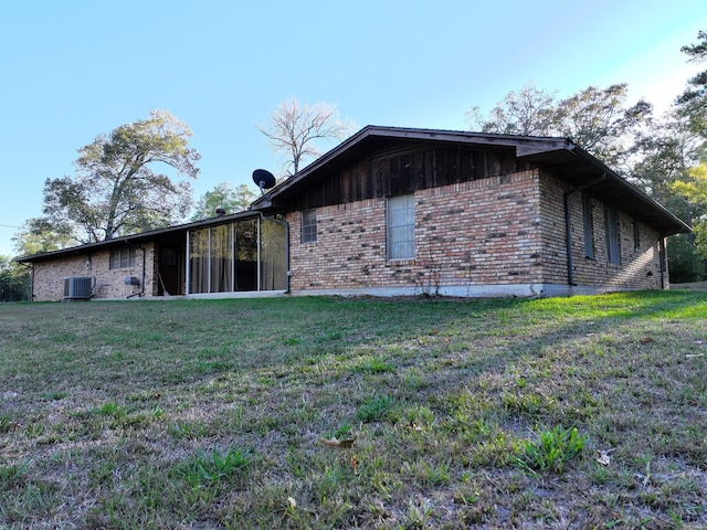 view of side of home featuring a lawn and central AC unit