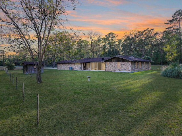 yard at dusk featuring a storage unit