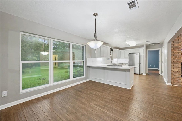 16 Briarcliff Ln, Lumberton, TX 77657 - kitchen featuring freestanding refrigerator, a peninsula, light countertops, and dark wood-style flooring
