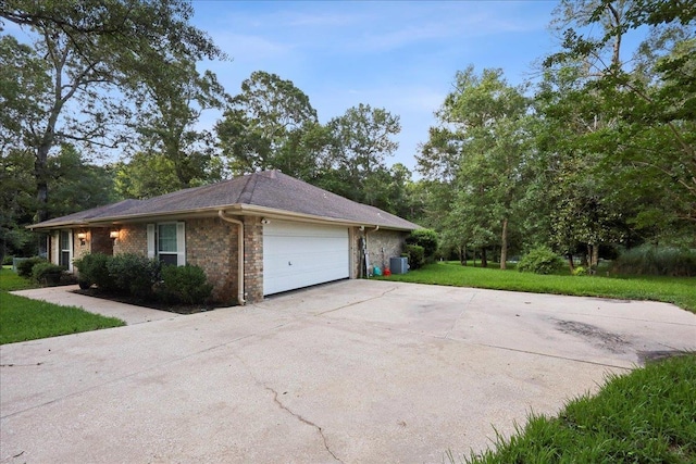 16 Briarcliff Ln, Lumberton, TX 77657 - view of side of property featuring a garage, concrete driveway, a yard, and stone siding