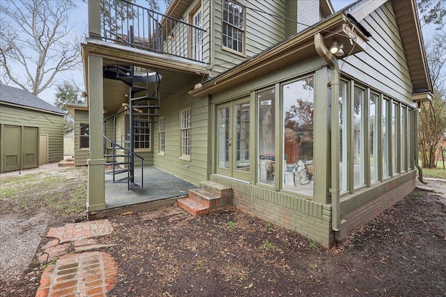 view of side of home with entry steps and a sunroom