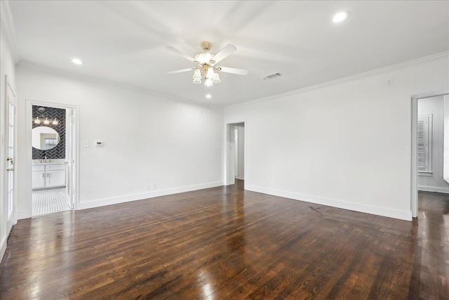 unfurnished room with dark wood-style floors, ornamental molding, visible vents, and baseboards