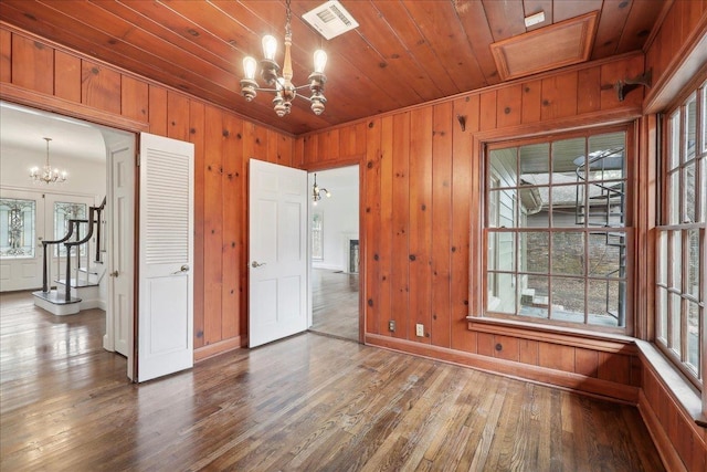 spare room with wood finished floors, wooden ceiling, visible vents, and an inviting chandelier