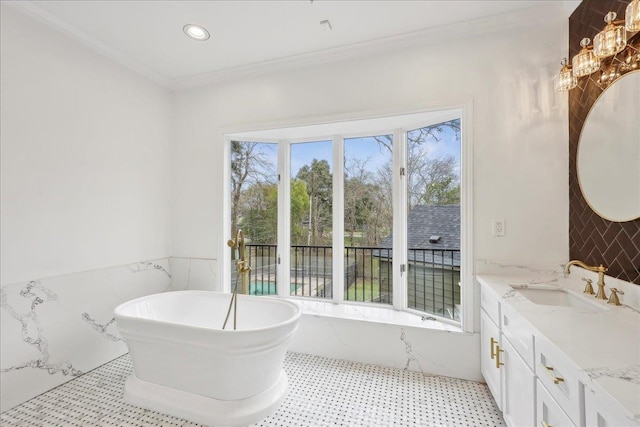 full bath featuring a soaking tub, ornamental molding, vanity, tile walls, and recessed lighting