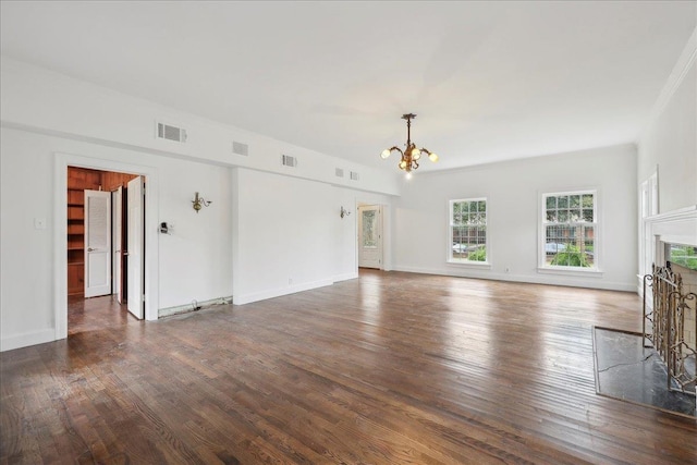 unfurnished living room featuring dark wood-style flooring, visible vents, a notable chandelier, and a fireplace