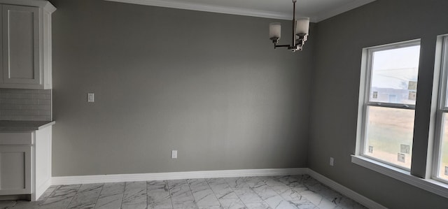 unfurnished dining area with ornamental molding and an inviting chandelier