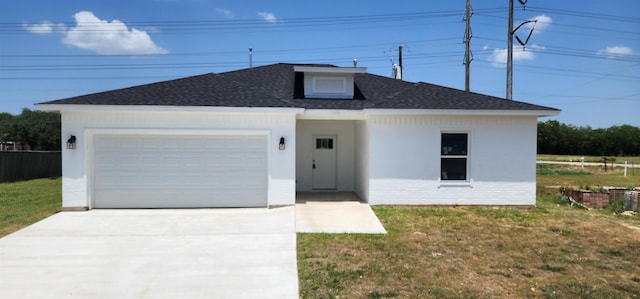 view of front of home with a front yard and a garage