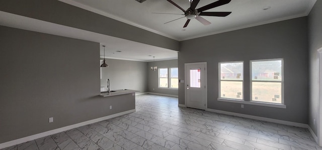 interior space featuring ceiling fan with notable chandelier, ornamental molding, and sink