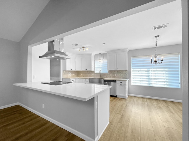 kitchen with stainless steel dishwasher, wall chimney range hood, a sink, black electric cooktop, and a peninsula