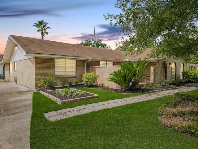 ranch-style home featuring brick siding and a shingled roof