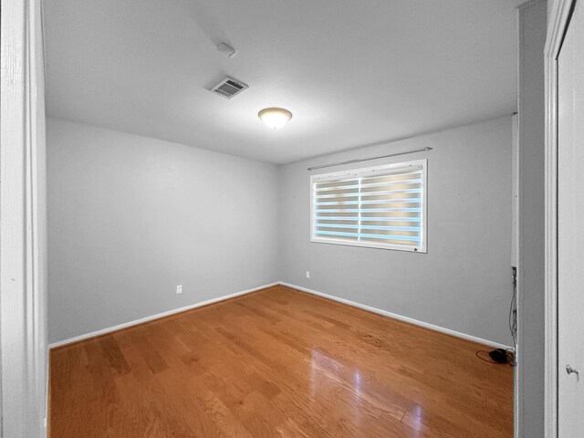 unfurnished room with wood finished floors and baseboards