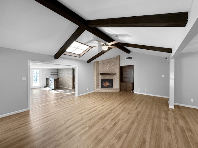 unfurnished living room featuring a brick fireplace, ceiling fan, baseboards, and light wood finished floors