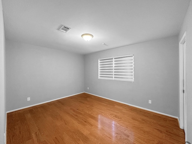 unfurnished room featuring wood finished floors and baseboards