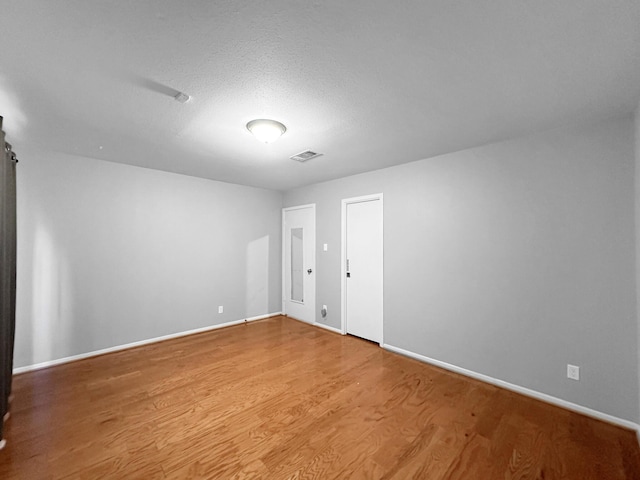 unfurnished room with wood finished floors and baseboards