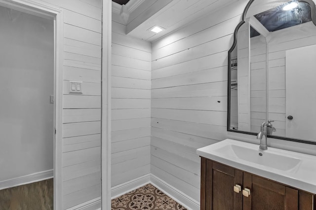 bathroom featuring vanity and wood walls