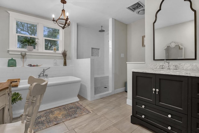 bathroom featuring vanity, plus walk in shower, and a notable chandelier