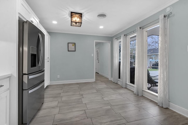 kitchen with white cabinetry, crown molding, and stainless steel fridge with ice dispenser