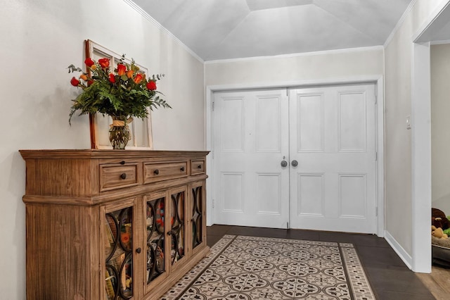 entryway featuring ornamental molding and dark tile patterned flooring