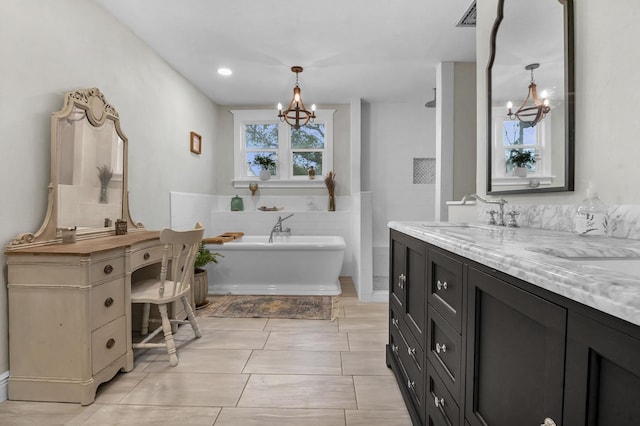 bathroom with tile patterned flooring, vanity, a washtub, and a notable chandelier