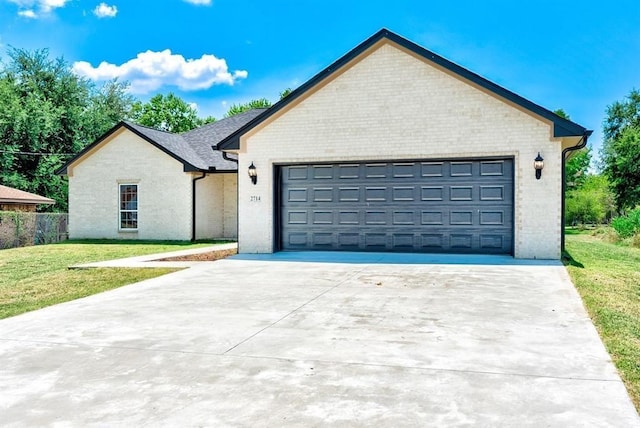 view of front of property with a garage and a front lawn