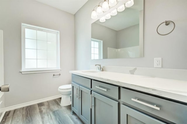 bathroom featuring a shower, hardwood / wood-style floors, vanity, and toilet