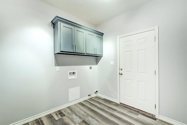 washroom featuring electric dryer hookup, washer hookup, light hardwood / wood-style flooring, and cabinets