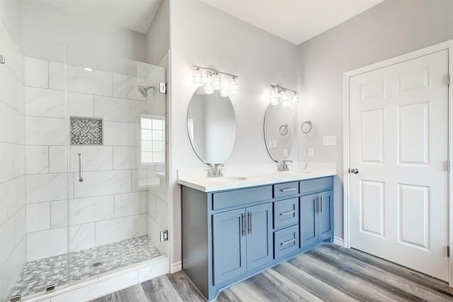 bathroom with wood-type flooring, vanity, and walk in shower