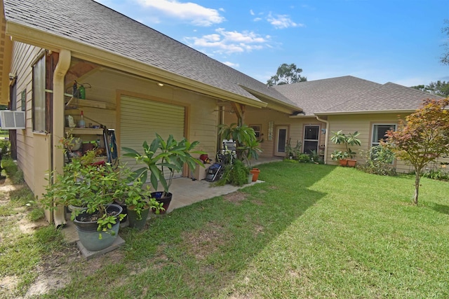 115 Pr 5250, Warren, TX 77664 - rear view of house featuring a shingled roof, a lawn, a patio area, and a garage